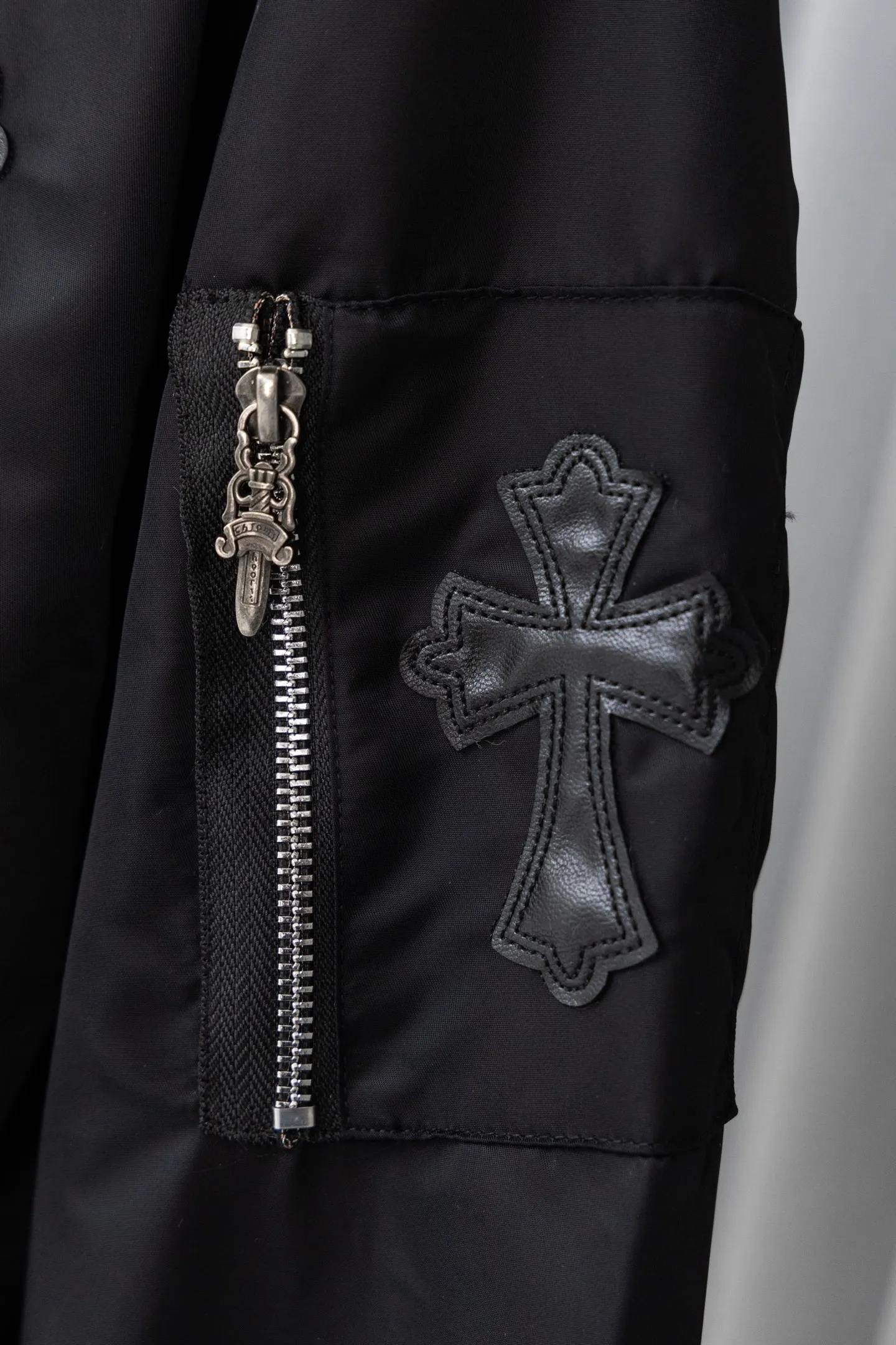 P410 Style No.: S045 This is a velvet baseball jacket from **Chrome Hearts**. It is a representative item of the brand that combines dark pioneer style with American street culture. It is also a trendy item that combines personality and warmth in autumn and winter. Design Highlights Iconic Elements: The brand’s classic cross leather embroidery is embellished throughout the body, paired with metallic hardware decorations (such as zipper pullers and hang tags). It combines Gothic religious symbols with heavy metal style, which is highly recognizable and is an intuitive embodiment of Crow Heart’s “dark luxury” tone.  Style and structure: It adopts the classic baseball uniform style, with a stand-up collar design and a two-way zipper, which is neat and stylish; the zipper pockets on the sleeves and the diagonal pockets on the body not only enhance the street feel, but are also practical.  Material splicing: The outer layer is made of high-density windproof fabric, and the inner layer is filled with velvet material, which has excellent thermal insulation performance; the threaded design of the collar and cuffs improves the overall crispness and wearing comfort. Craftsmanship and Quality: The cross is veneered using imported leather + hand-embroidered craftsmanship, with fine stitching and strong three-dimensional effect; the metal hardware has been distressed to give it a vintage and distressed texture, and the details reflect the brand's strict requirements for craftsmanship.  The velvet inner liner is evenly and fully filled, and the splicing process with the outer fabric is rigorous. It is not easy to deform after long-term wear, and has excellent warmth retention and durability. Style and Outfit This jacket is based on dark street style, and its black main tone is versatile and high-end. It can be paired with ripped jeans and Martin boots to create a cool street style in daily life; it can also be worn with a turtleneck sweater and a long coat on the outside. It can be layered to create layers, making it easily suitable for niche trendsetters, rock enthusiasts and other diverse style groups. It is an eye-catching item in the autumn and winter wardrobe that shows individuality. Size: s-XL Color: Black